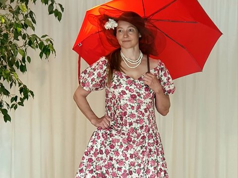 Willkommen in unserer Malakademie München Man sieht eine Frau, die eine roten Regenschirm in der Hand hält.