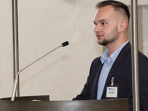 Ein Mann spricht in ein Mikrofon.