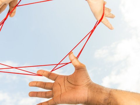 Zwischen Händen gespannter Faden | © iStock/helovi